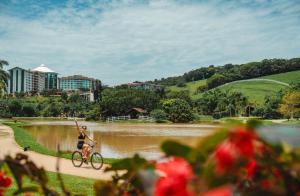 加斯帕Fazzenda Park Resort的骑着自行车在河边的女人