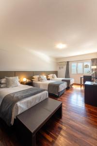 玛德琳港托洛萨酒店的酒店客房设有两张床和一张桌子。