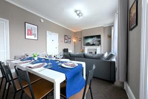 伦敦STUNNING 3 Bedroom Serviced Flat IN North London的一间带桌子和沙发的用餐室