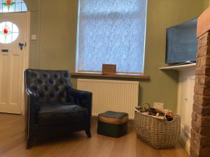 AdlingtonAdlington Cottage, Lancashire的客厅配有椅子和电视