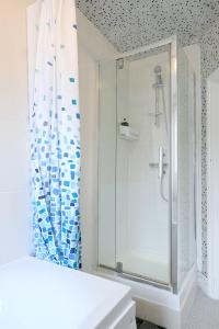 伦敦STUNNING 3 Bedroom Serviced Flat IN North London的带淋浴的浴室和玻璃门