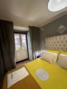 里斯本apartamet in Bairro alto 1的一间卧室配有黄色的床和黄色的毯子