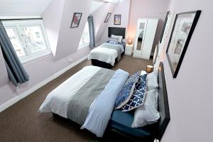 伦敦STUNNING 3 Bedroom Serviced Flat IN North London的一间卧室设有两张床和两个窗户。