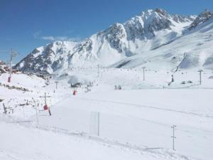 拉姆吉Résidence Pic Du Midi - Studio pour 4 Personnes 724的一座雪覆盖的滑雪场,其背景是一座山