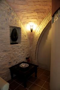 奥苏纳Viña Zarzarrosa Osuna的一间设有石墙、桌子和灯的房间