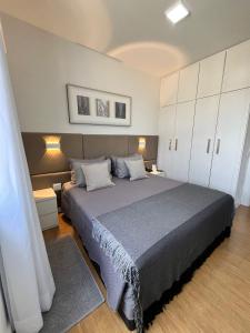 贝洛奥里藏特Flat Premier 14 Max Savassi的一间卧室配有一张大床和白色橱柜。