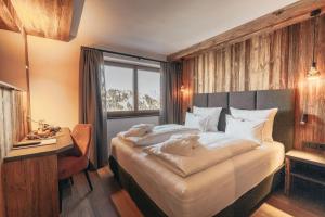 塞尔瓦迪加尔代纳山谷Hotel Piz Seteur的一间卧室配有一张床、一张书桌和一个窗户。