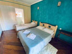 瓜拉雷马Hotel Beira Rio Guararema的一间卧室设有两张床和蓝色的墙壁