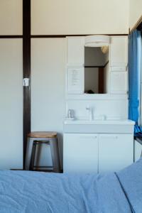 热海Atami-Ajironokaze - Vacation STAY 87959v的一间卧室配有床、水槽和凳子