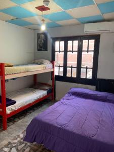 罗萨里奥Coolraul Hostel的客房设有两张双层床和天花板。
