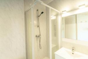 莱索尔Résidence Le 1650 - Studio 834的带淋浴和盥洗盆的白色浴室