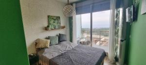 卡斯特利翁-德拉普拉纳Peñiscola - Casa Mirador mit Gemeinschaftspool的一间卧室设有一张床,享有阳台的景色