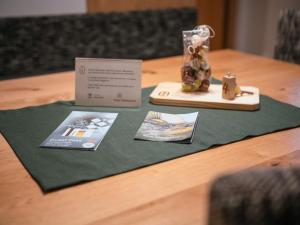 卢塔戈Zum Sonnentor App Larix 2的一张桌子,桌子上放有证书和花瓶