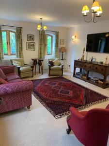 TettenhallStable Cottage的客厅配有红色家具和平面电视