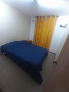 巴耶纳尔Departamento vallenar的一间卧室配有蓝色的床和黄色窗帘