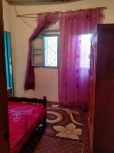 BawatiNew Oasis的一间卧室配有床和一个带粉红色窗帘的窗户。