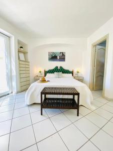 阿纳卡普里Casa Pippo 2的白色卧室设有一张带绿色床头板的大床