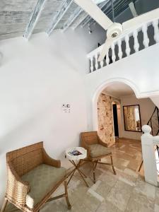 卡塔赫纳Peregrinos Hostel Cartagena de Indias的客厅配有吊扇和椅子
