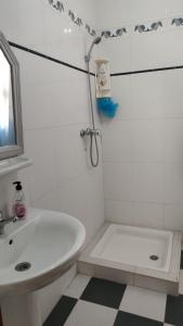 乌季达Logement calme très proche du centre的带淋浴和盥洗盆的白色浴室