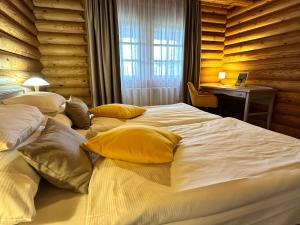 科什保尔洛格Szent Orbán Erdei Wellness Hotel的一间卧室配有两张带黄色枕头的床和一张书桌