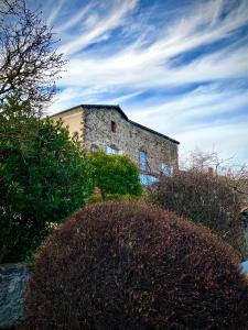 Vieille-Brioude圣文森特冬宫住宿加早餐旅馆的一座古老的石头建筑,前面有灌木丛