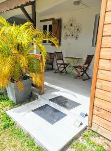 圣安尼Appartement - Résidence piscine La Villa Bèl的庭院配有桌椅和植物