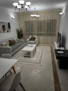 沙迦Smart Home Vacation Home的客厅配有沙发和桌子