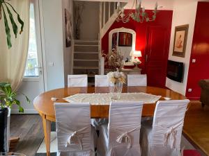 拉瓦勒Chez Patou的一间带桌子和白色椅子的用餐室