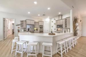 拉斯维加斯HotTub, Pool, Waterfall, RV parking 5BR Lux Home的厨房配有白色的柜台和白色的凳子