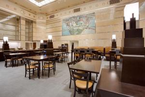 匹兹堡匹兹堡市中心德鲁里广场酒店的一间设有桌椅的餐厅,墙上有地图