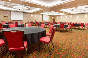印第安纳波利斯印第安纳波利斯卡梅尔德鲁酒店的一间会议室,配有桌子和红色椅子
