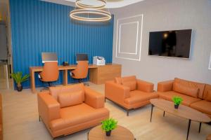 吉布提Best Western Premier DJ Hotel的一间配备有橙色家具和平面电视的等候室