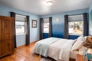 拉克罗斯French Island Whot Tub, Kayak, Lake View, Ev的一间蓝色卧室,配有床和2个窗户