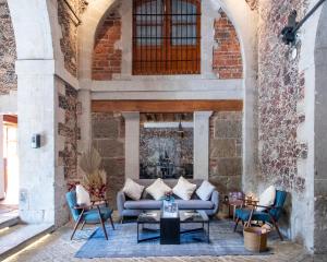 墨西哥城Casa de la Luz Hotel Boutique的庭院配有沙发、椅子和壁炉