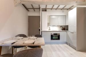 鲁昂Villa Caron - Appartements haut de gamme avec chambre hyper centre的厨房以及带桌椅的用餐室。