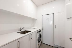 瓦纳卡Lakeside Luxury Studio Apartment的白色的厨房配有水槽和冰箱