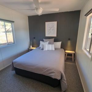 Quorn皮奇里奇公园山林小屋的一间卧室设有一张大床和两个窗户。