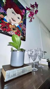 贝洛奥里藏特Oásis Urbano com Netflix na Raja Gabáglia的酒杯桌子和盆栽植物