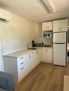 Quorn皮奇里奇公园山林小屋的厨房配有白色橱柜和白色冰箱。