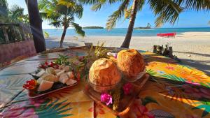 提克豪Tikehau HereArii Airbnb的海滩上一张桌子,上面有面包和一盘食物