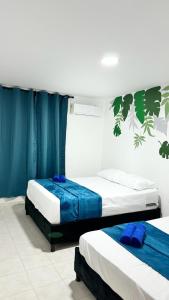 卡塔赫纳Marbar Cartagena Hostel的配有蓝色窗帘的客房内的两张床