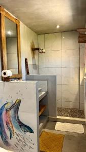 El Paredón Buena VistaSHANTI SURF CAMP的浴室设有淋浴,装饰有海豚绘画作品