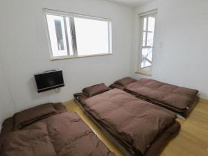 俱知安町Hirafu House 8的一间卧室配有两张床和电视。