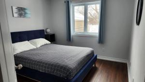 加蒂诺Bungalow Luxieux et calme的窗户客房内的一张蓝色的床