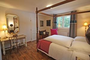 Saint-Brice-sur-VienneLa musardiere de louisiane的一间卧室配有一张床、一张桌子和一面镜子
