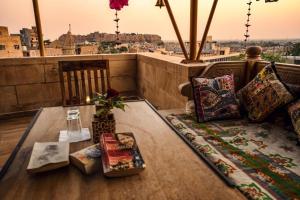 斋沙默尔Hotel Royal Lakhina Jaisalmer的带阳台的客房配有桌子和枕头