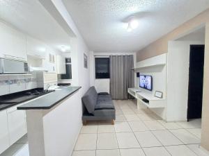 里约热内卢Apê UNIFA-EsSLog Condomínio com estacionamento的白色的厨房配有椅子和电视