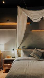 恒春古城隱室x迷路 Hermit Inn Hengchun的一间卧室配有一张床,床的上方是窗帘