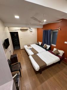 马杜赖David Residency的一间大卧室,配有两张床和电视