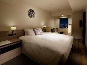 东京Sunshine City Prince Hotel Ikebukuro Tokyo的酒店客房设有一张大床和一张书桌。
